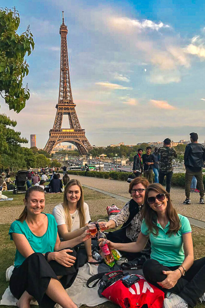 Grupo de mulheres faz piquenique no Trocadéro, com a Torre Eiffel ao fundo